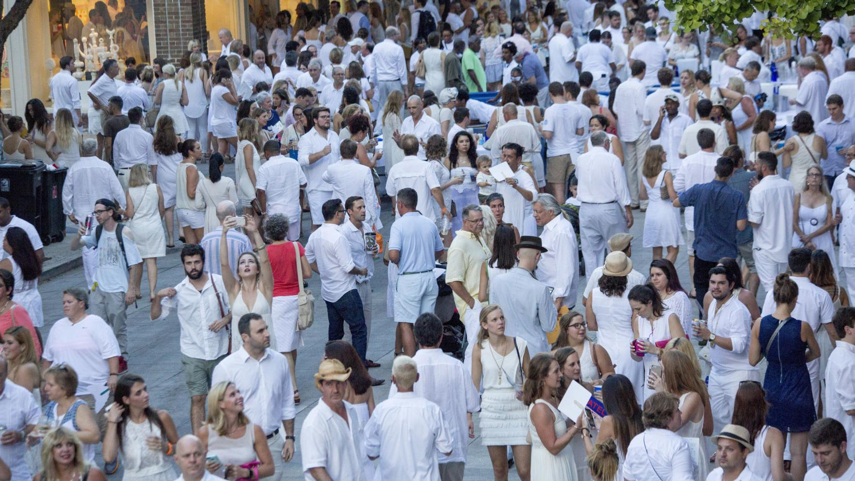 Woman in red shirt amidst people in white clothing